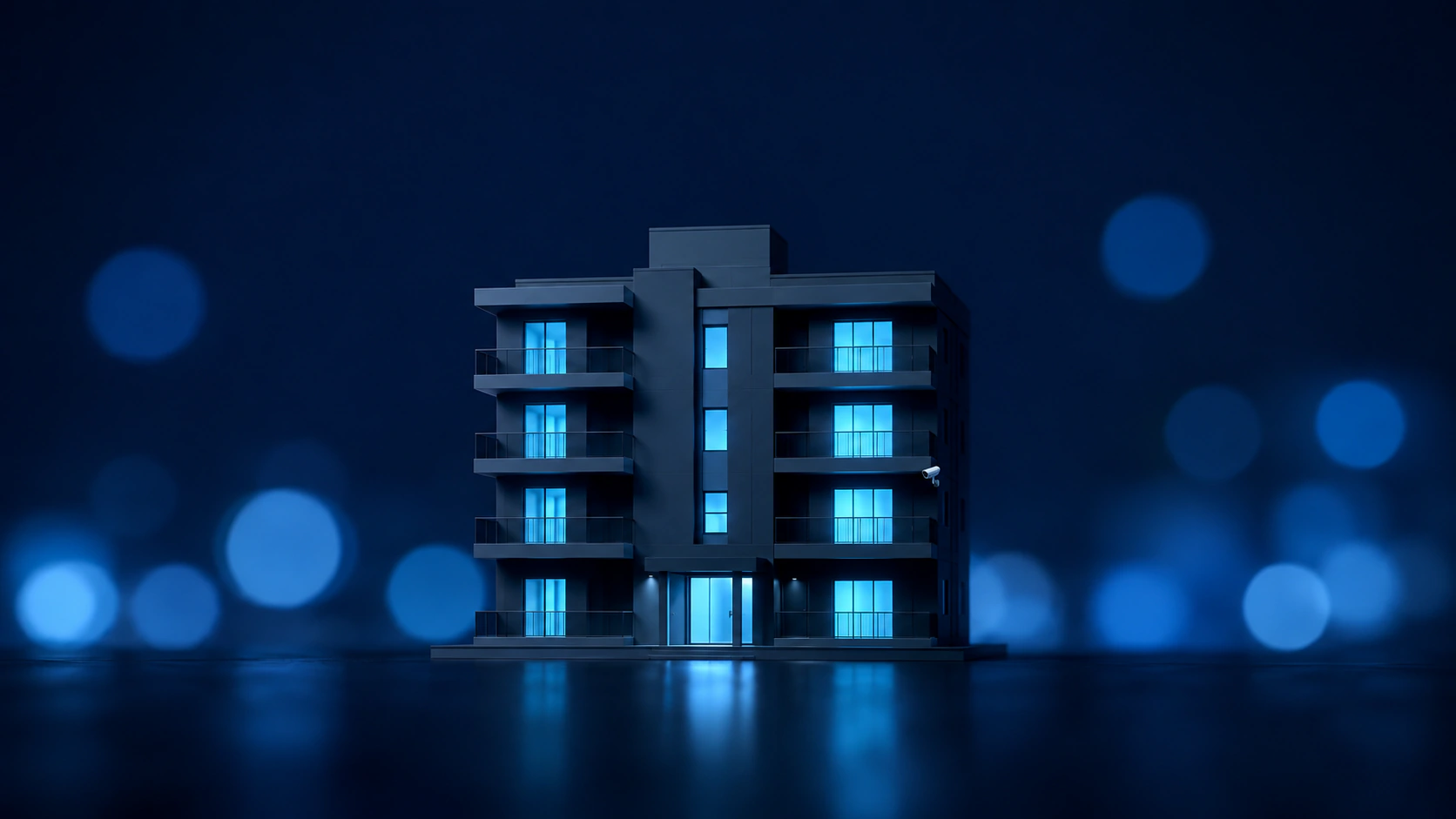 Mehrfamilienhaus bei Nacht mit Überwachungskamera an der Fassade.